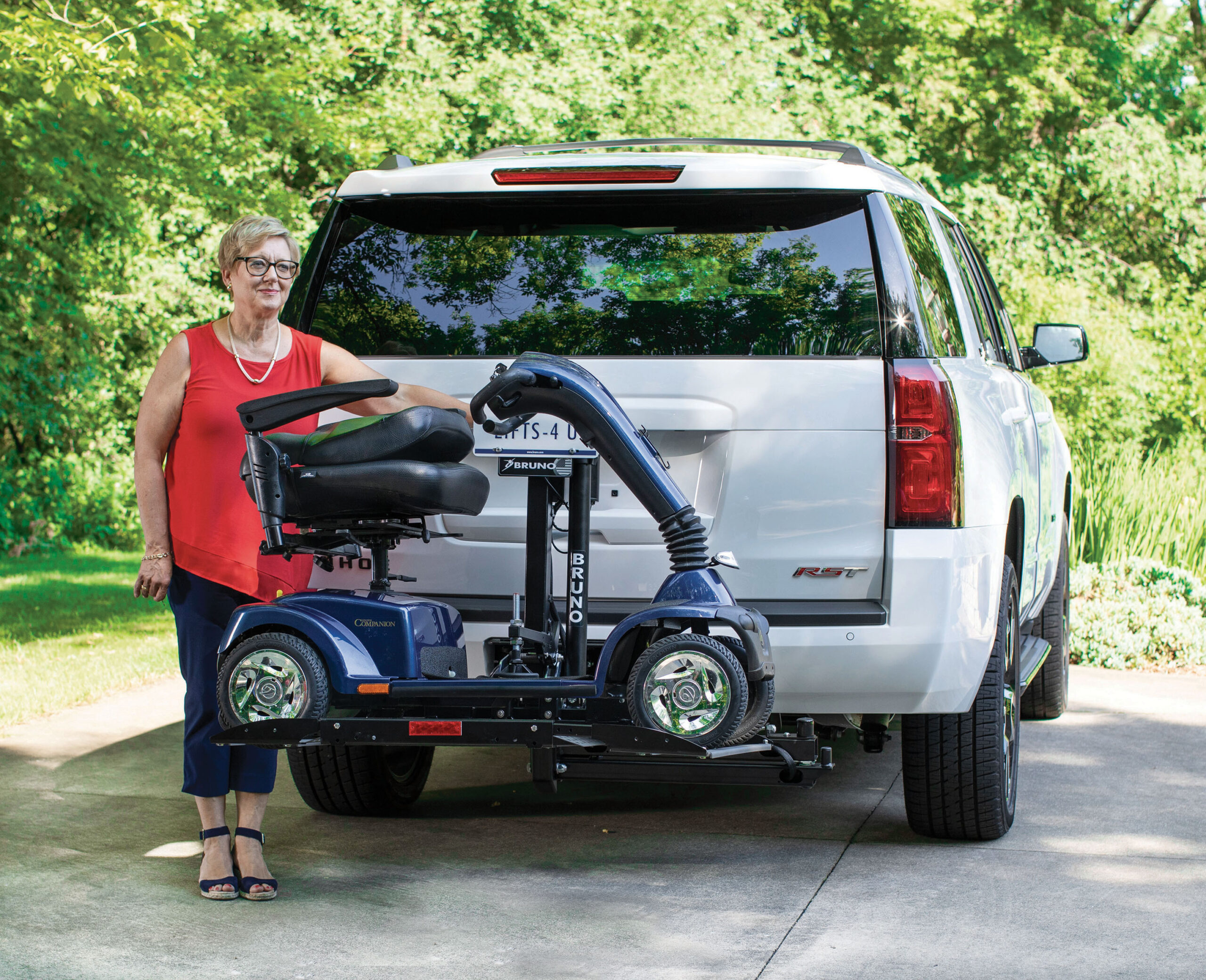 Woman operating a vehicle lift on the back of a suv