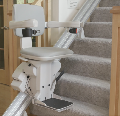 a stair lift chair at the bottom of carpeted stairs